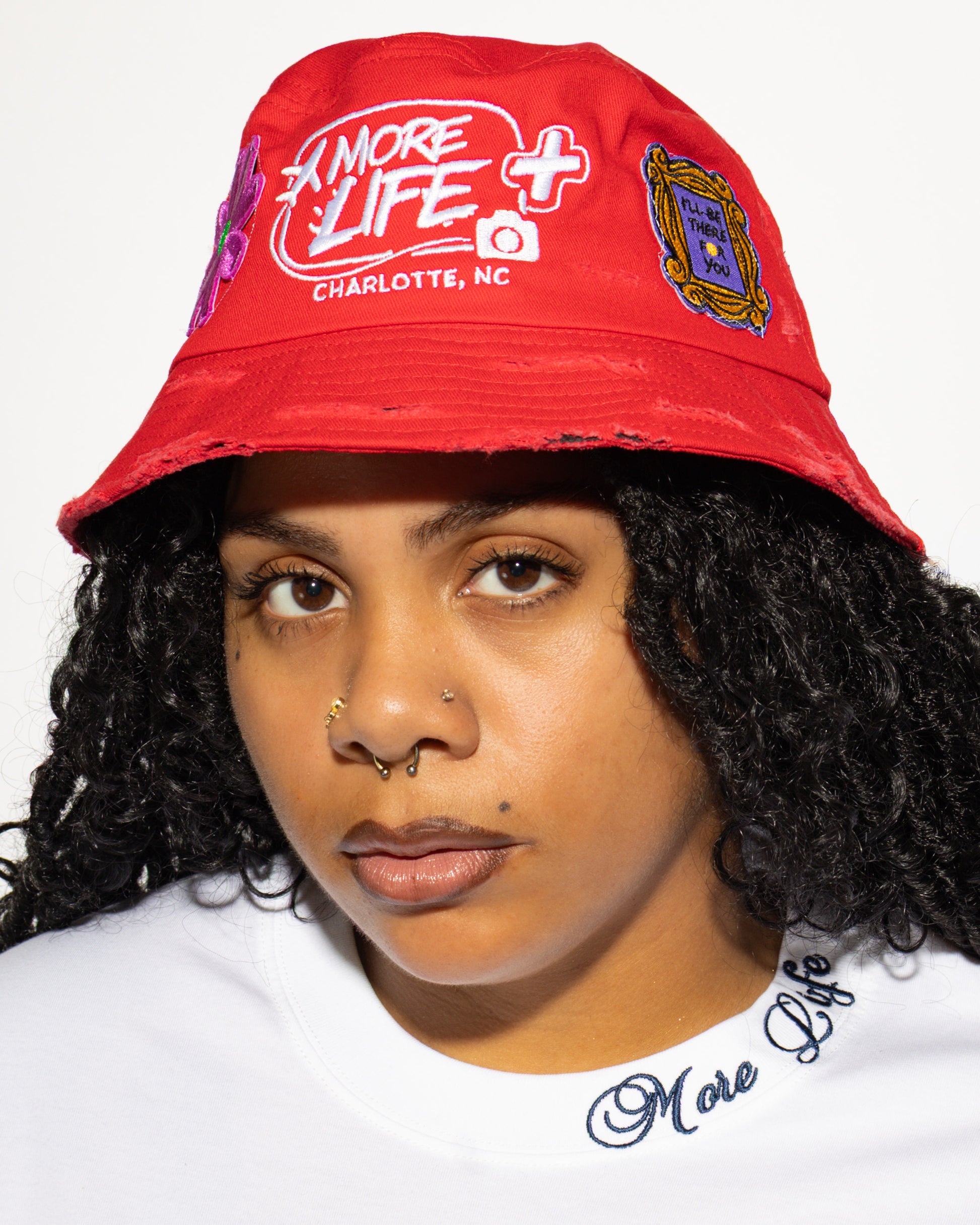 More Life CLT R&B Patchwork Distressed Bucket Hat Red – side view on model showing U chain pendant patch and More Life Charlotte NC logo