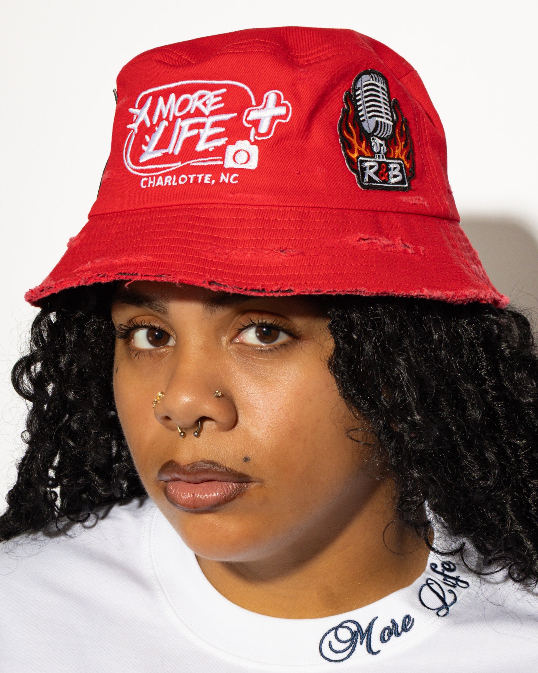 More Life CLT R&B Patchwork Distressed Bucket Hat Red – front view on model showing More Life Charlotte NC logo and R&B microphone patch