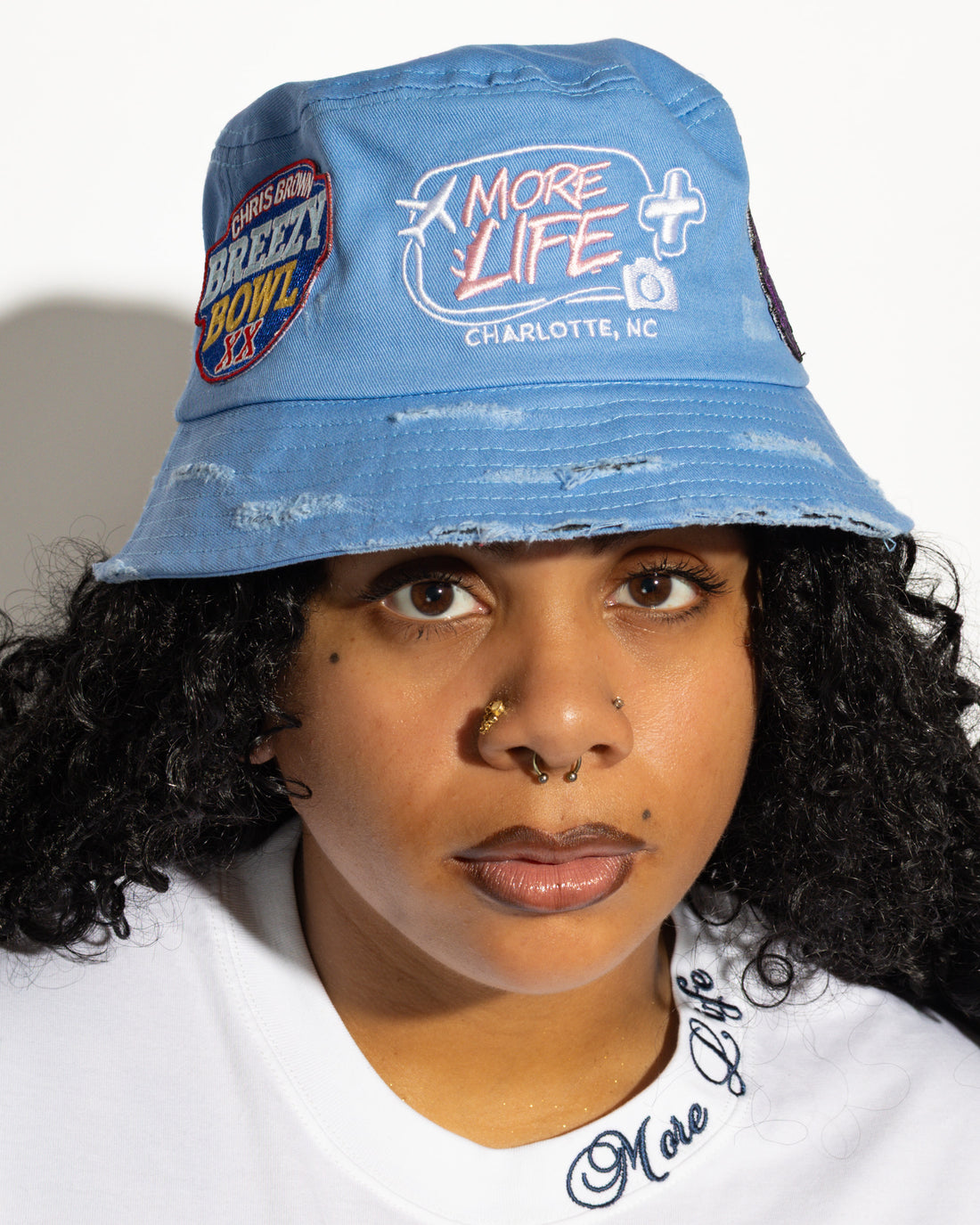 More Life CLT Breezy Bowl XX Patchwork Distressed Bucket Hat Light Blue – front view on model showing Breezy Bowl XX patch and More Life Charlotte NC logo