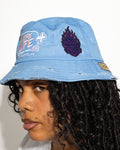 More Life CLT Breezy Bowl XX Patchwork Distressed Bucket Hat Light Blue – side view on model showing Indigo purple flame patch and More Life Charlotte NC logo