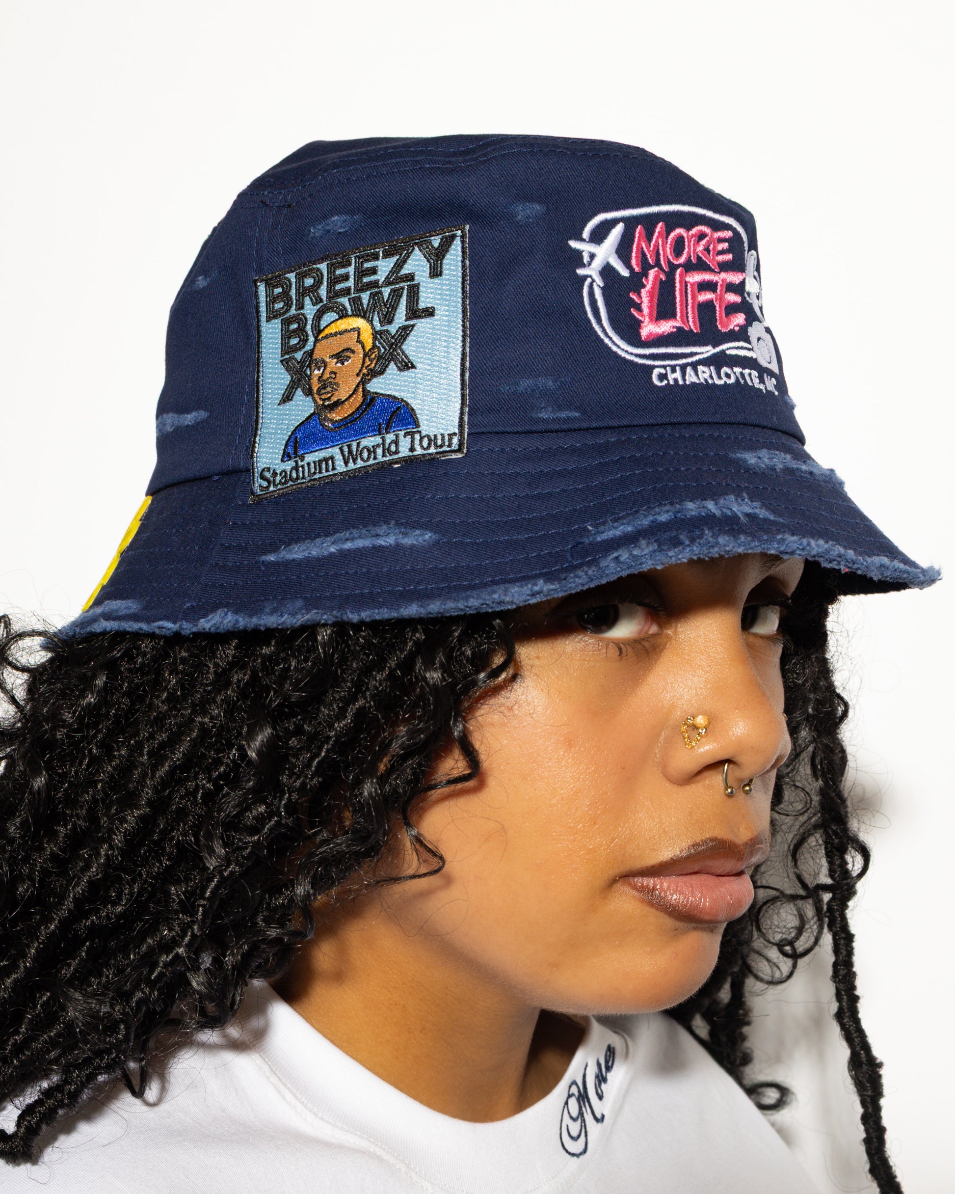 More Life CLT CB Breezy Bowl Stadium Tour Patchwork Distressed Bucket Hat Navy Blue – side view on model showing Breezy Bowl XX Stadium World Tour illustrated patch and More Life Charlotte NC logo
