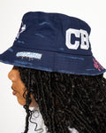 More Life CLT CB Breezy Bowl Stadium Tour Patchwork Distressed Bucket Hat Navy Blue – side view on model showing CB varsity letters patch and graffiti drip tab on brim