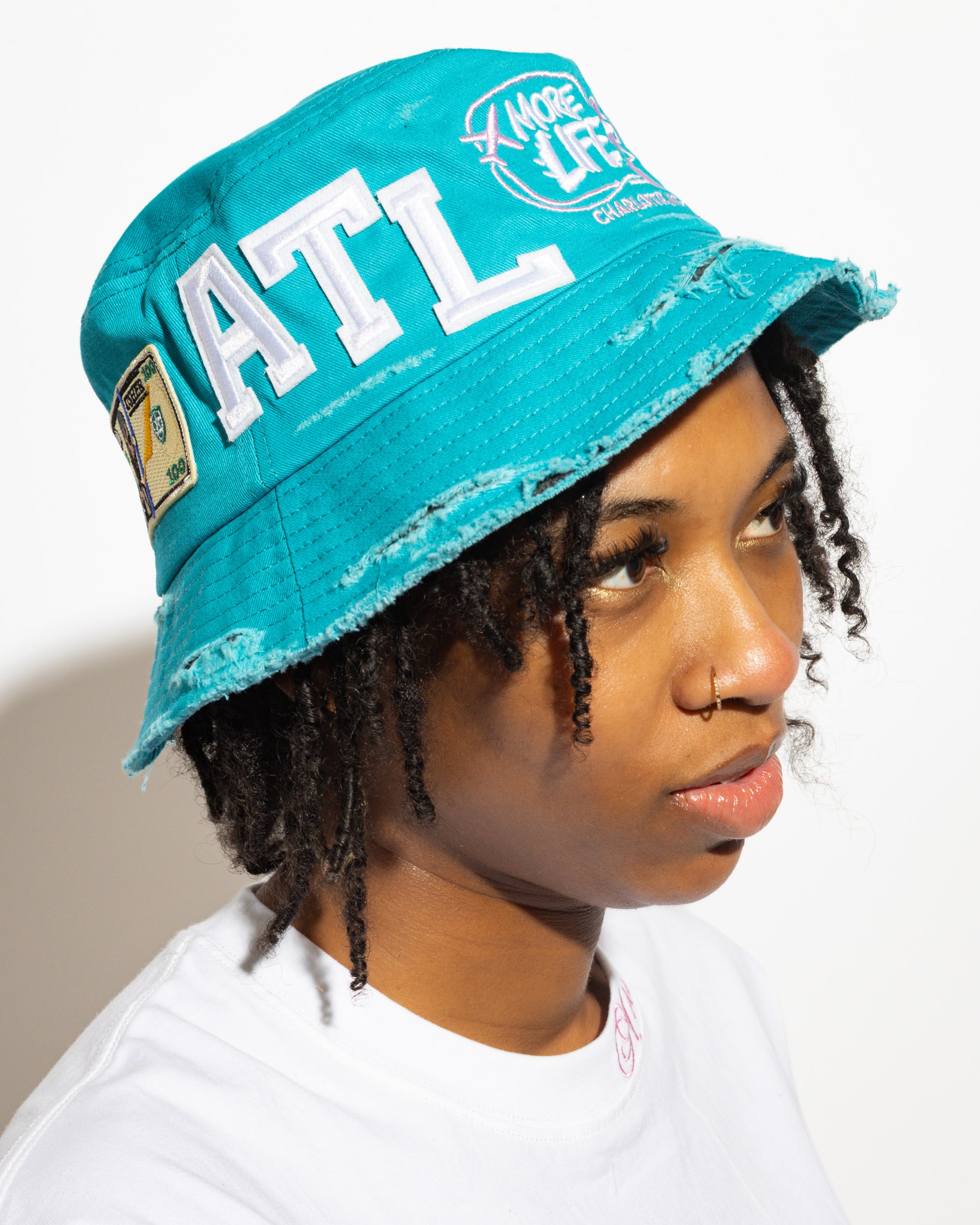 More Life CLT Usher Raymond ATL Patchwork Distressed Bucket Hat Teal – front view showing ATL lettering and More Life CLT logo patch