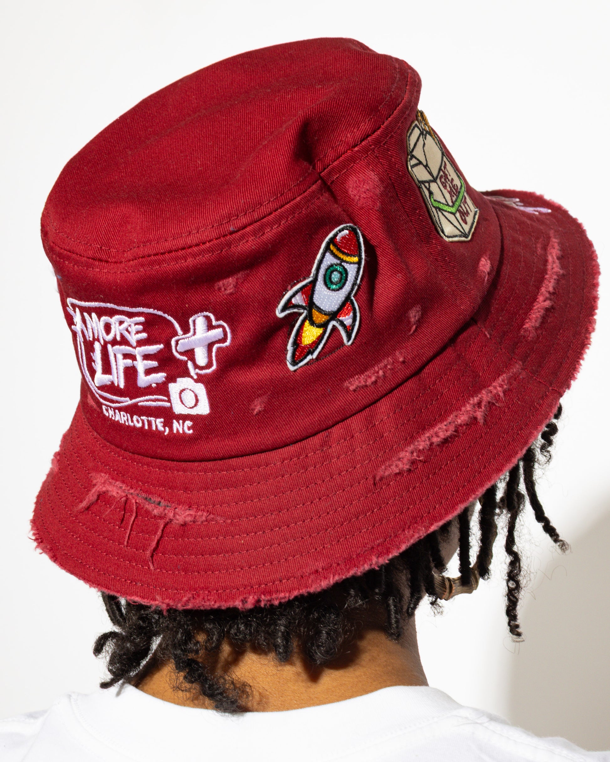 More Life CLT Eat Me Out Patchwork Distressed Bucket Hat Burgundy – back view showing rocket ship patch and More Life Charlotte NC logo