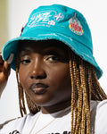 More Life CLT Daisy New York Patchwork Distressed Bucket Hat Teal – side view on model showing More Life Charlotte NC logo and New York city badge patch